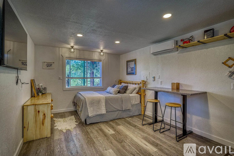 A bedroom with a bed, a wooden cabinet, and a bar area.