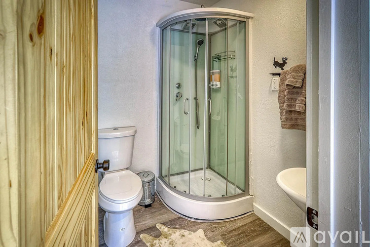 A bathroom with a toilet, a glass shower stall, and a white bathtub.