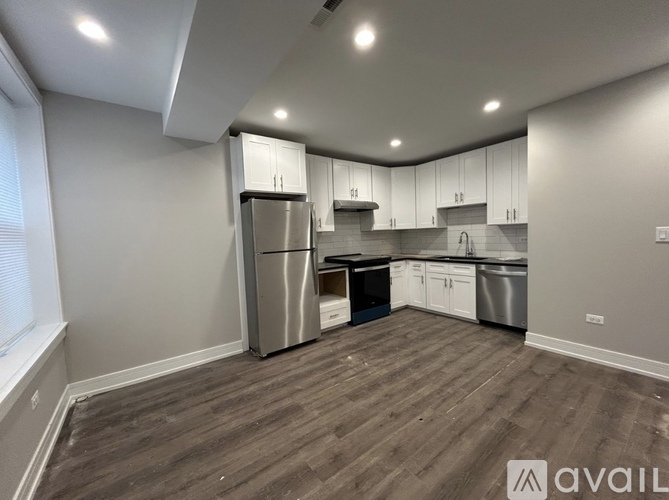 A kitchen with wooden floors and stainless steel appliances is available.