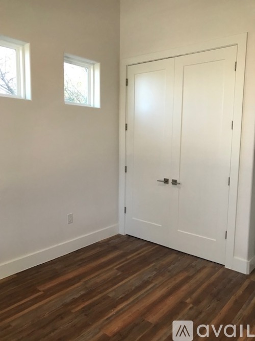 A room with a white door and two windows.
