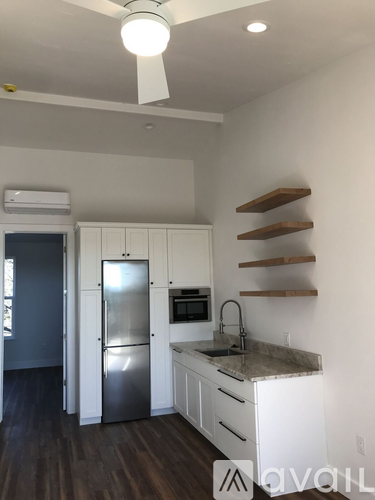 A kitchen with white cabinets and a stainless steel refrigerator.