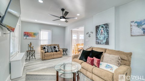 A bedroom with a bed, a ceiling fan, and a window.