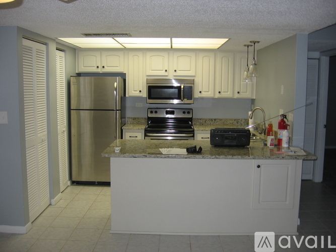 A kitchen with a granite countertop and stainless steel appliances.