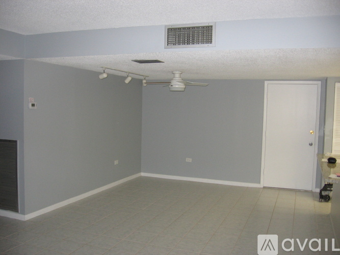 A room with a ceiling fan and a door.