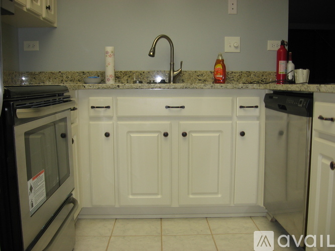 A kitchen with white cabinets and a granite countertop.