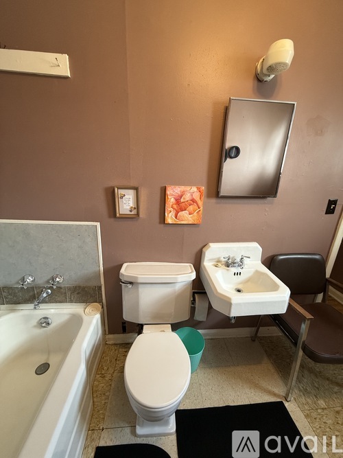 A bathroom with a toilet, sink, and tub.