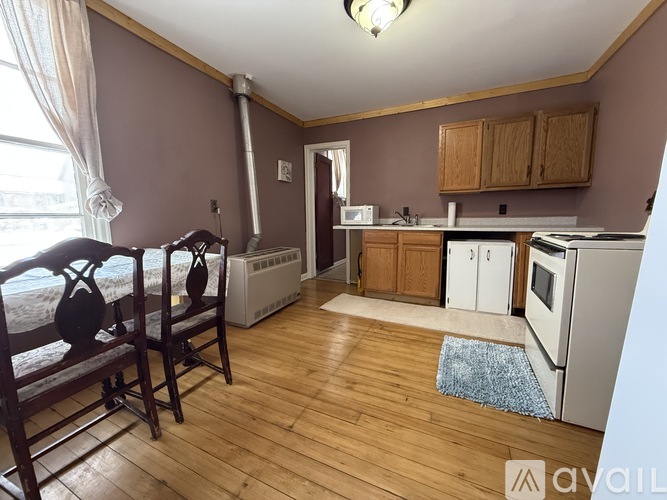 A kitchen with wooden floors and a white fridge.