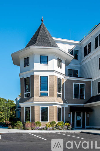 A large white house with a tower and a black roof.