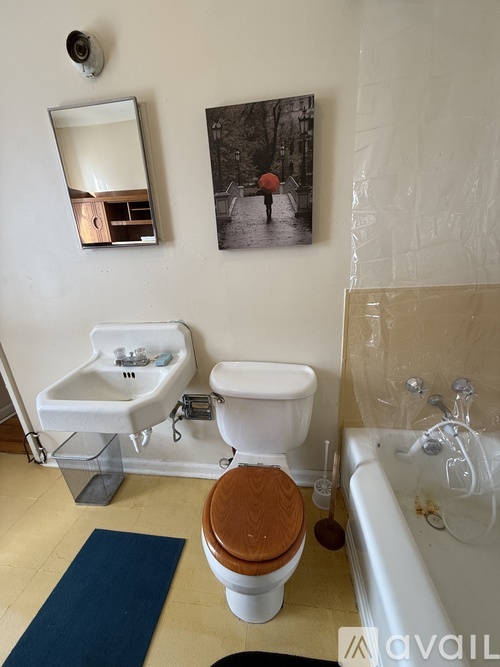 A bathroom with a toilet, sink, and mirror.