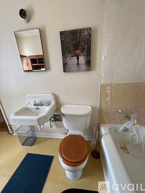 A bathroom with a toilet, sink, and mirror.