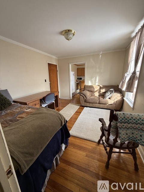 A bedroom with a bed, chair, and couch.