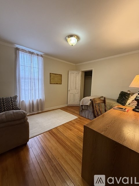 A living room with a couch, chair, and a lamp.