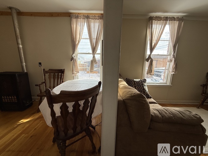 A living room with a brown wooden chair and a white table.