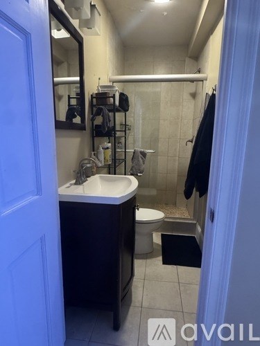 A bathroom with a sink, mirror, toilet and shower.