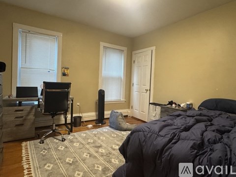 A bedroom with a bed, desk, and chair.