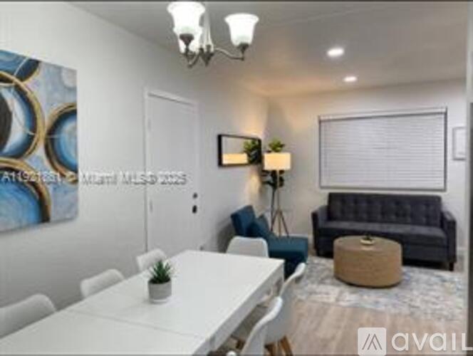A modern living room with a white dining table and a grey sofa.
