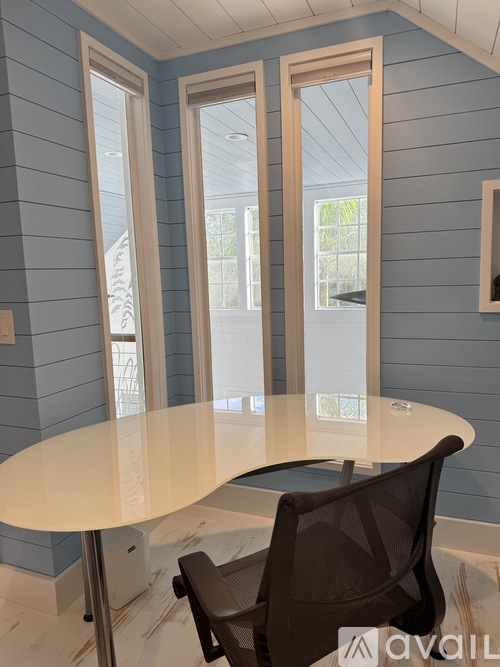 A dining room with a round table and a brown chair.