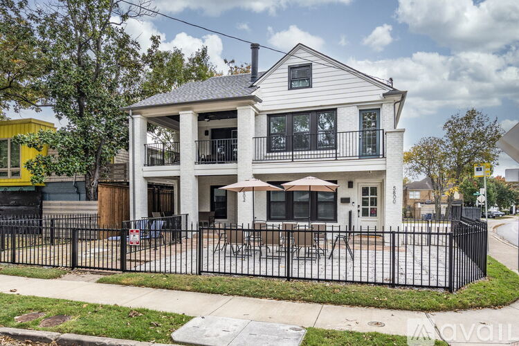A two-story house with a balcony and a black fence.