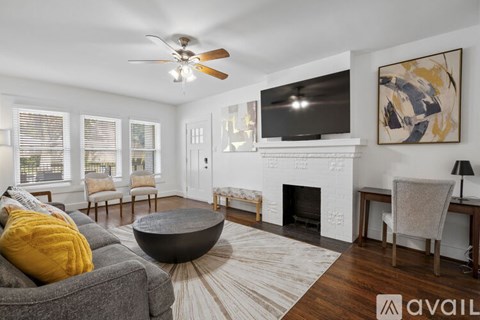 A living room with a grey couch and a fireplace.