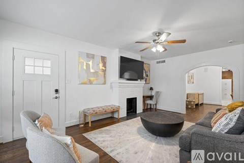 A living room with a grey couch, a black coffee table, and a television.