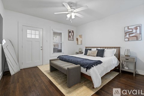 A bedroom with a large bed and a ceiling fan.