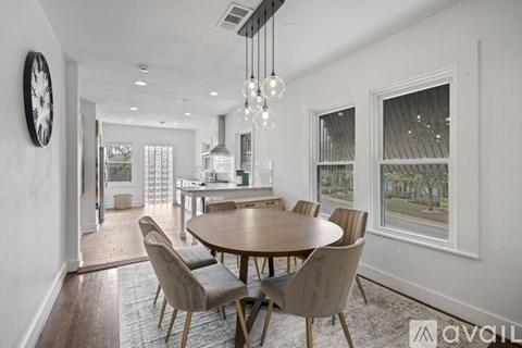 A dining room with a round table and chairs.