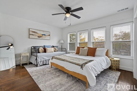 A bedroom with a large bed and a ceiling fan.