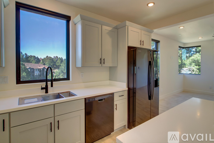 A kitchen with white countertops and a refrigerator.