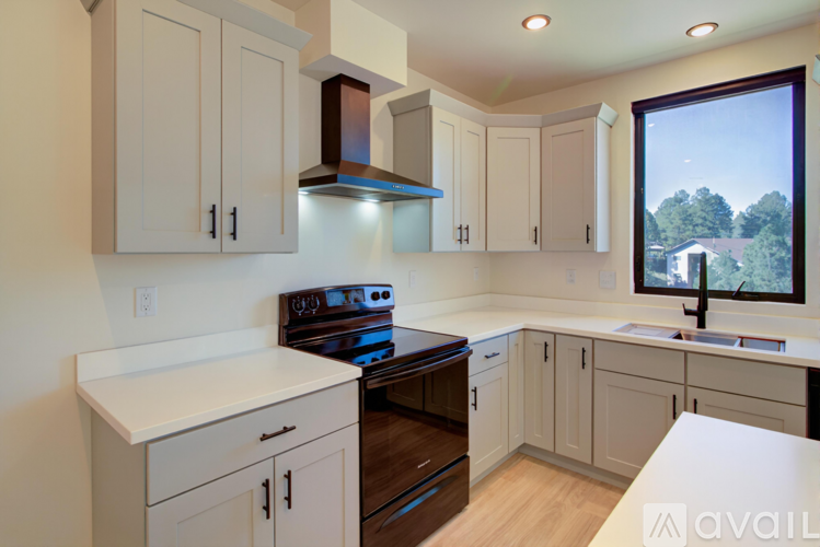 A kitchen with white cabinets and a stove top oven.