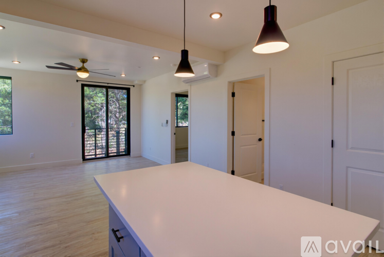 A spacious room with a long white counter and a ceiling fan.