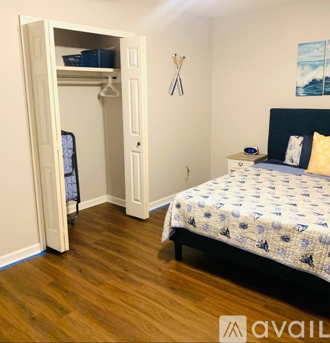 A bedroom with a bed, nightstand, and a closet with a door open.
