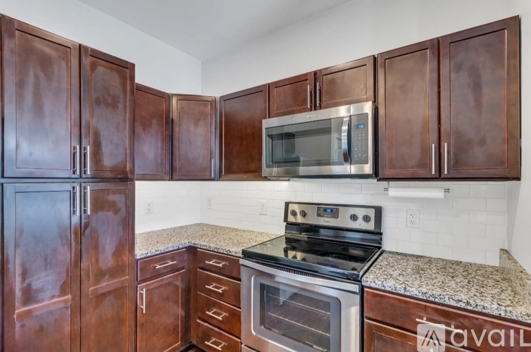 Brown cabinets in a kitchen with a stove and microwave.