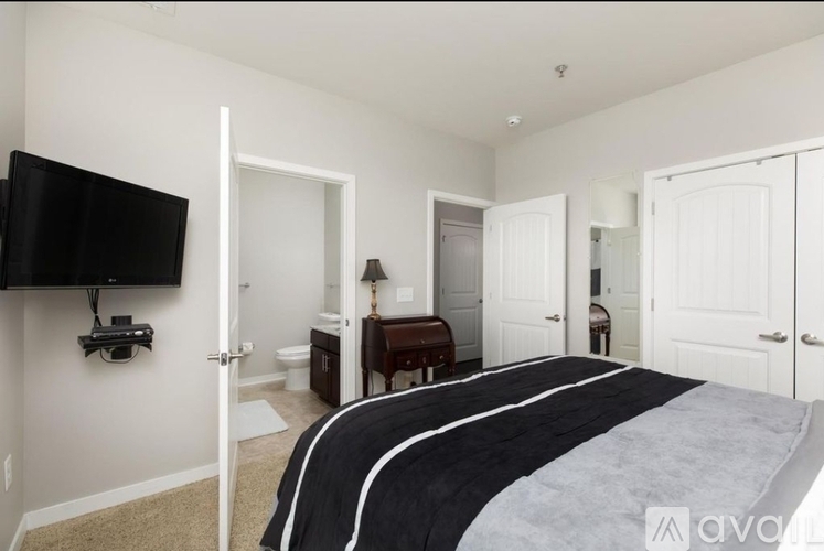 A bedroom with a large bed and a flat screen TV mounted on the wall.