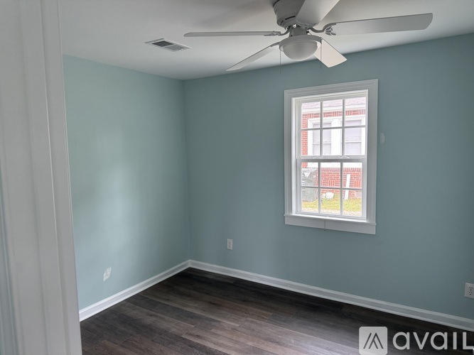 A room with a ceiling fan and a window.