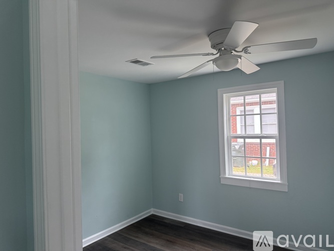 A room with a ceiling fan and a window.