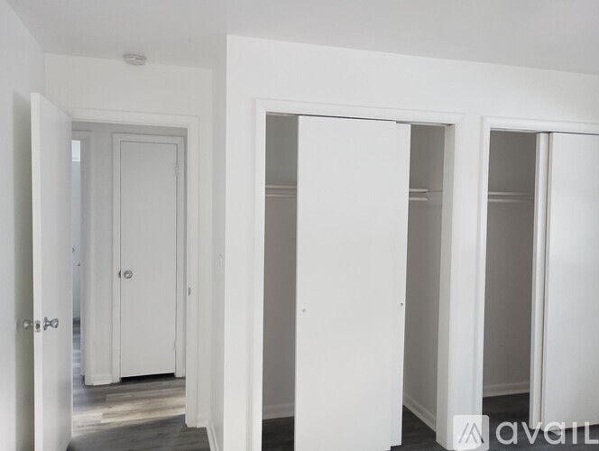 A hallway with white doors and a wooden floor.