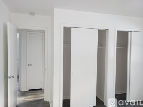 A hallway with white doors and a wooden floor.