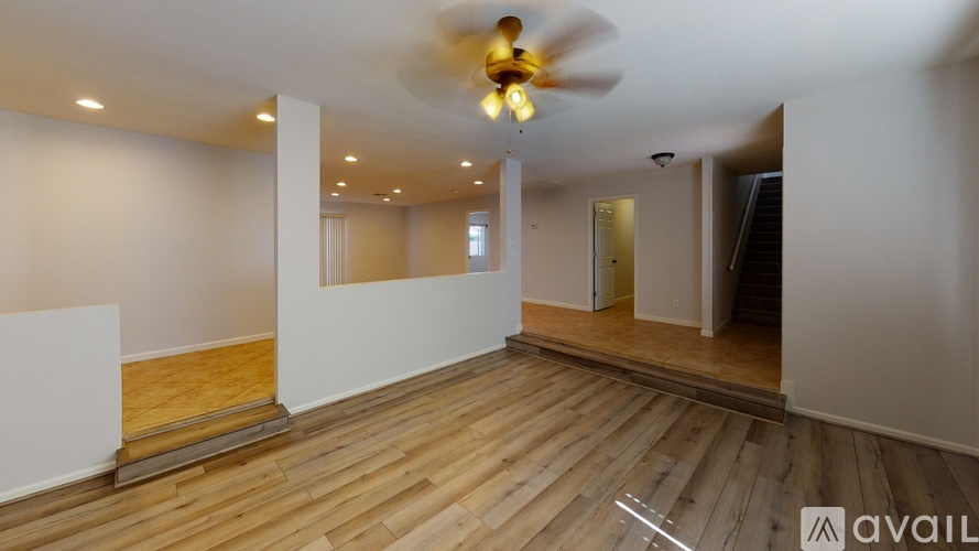 A room with wooden floors and a ceiling fan.