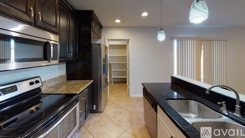 A kitchen with black cabinets and stainless steel appliances.