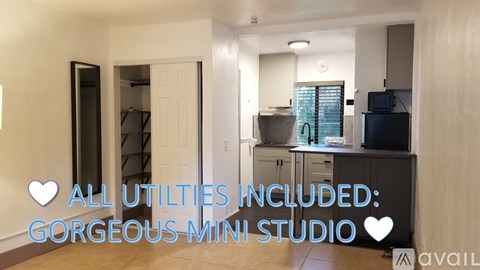 A room with a doorway leading to a storage area, a TV, and a window with blinds.