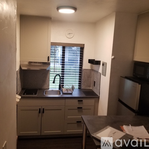 A kitchen with a sink and a window with blinds.