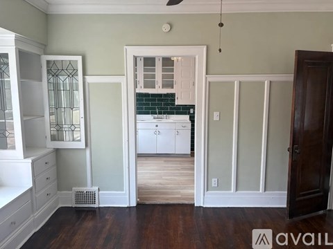 A kitchen with white cabinets and a green backsplash.