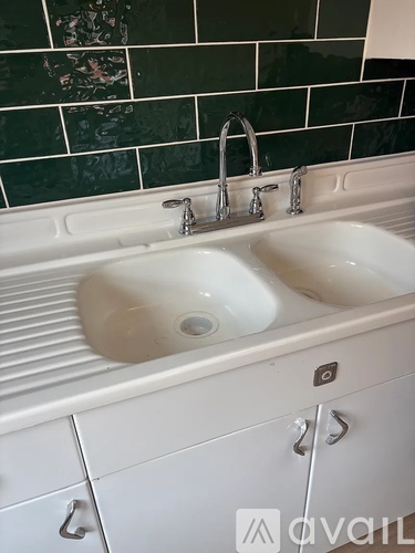 A white sink with a faucet is in the middle of a white counter.