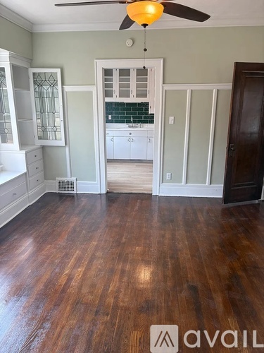 A room with wooden floors and a ceiling fan.