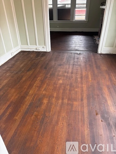 A room with wooden flooring and a window.