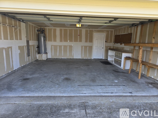 A spacious garage with a concrete floor and walls under construction.