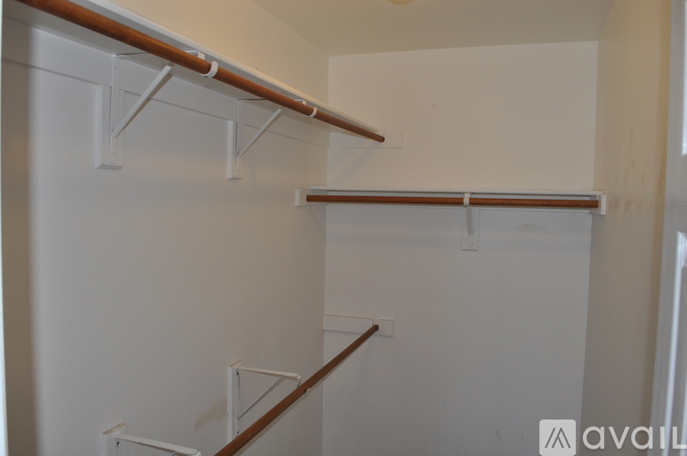 A white wall with a brown railing and a white shelf.
