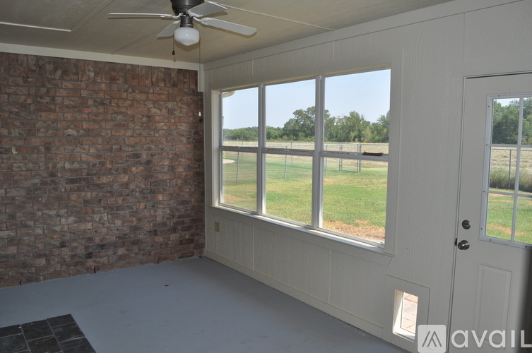 A room with a brick wall and a ceiling fan.
