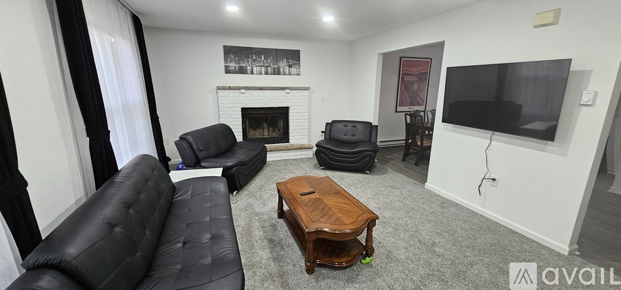 A living room with a fireplace and a flat screen TV.