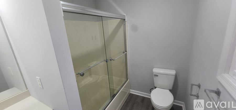 A white toilet in a bathroom with a glass shower door.